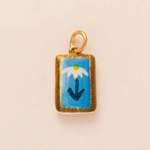 Close-up of retro enamel rectangular daisy pendant with gold hook on beige base