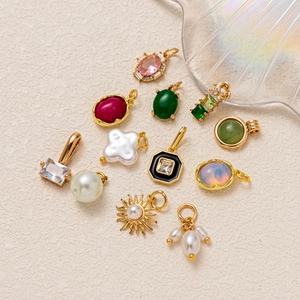 Lot de douze pendentifs soleil et pierres précieuses en acier inoxydable doré sur blanc