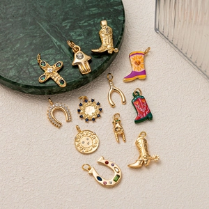 Set of 12 gold-plated brass pendants featuring cowboy boots, crosses, and horseshoes