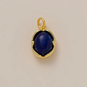 Détail d'un pendentif ovale en lapis-lazuli bleu avec cadre ondulé plaqué or et bélière