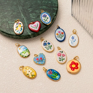 Diverse titaniumstalen hangers met kleurrijke ovale en hartvormige bloemmotieven