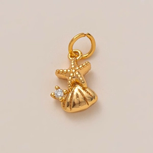 Détail du pendentif étoile de mer et coquillage doré avec pierre zircon et relief ciselé