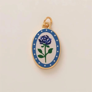 Detail van de gouden ovale hanger met blauwe roos emaille en witte polkadot rand