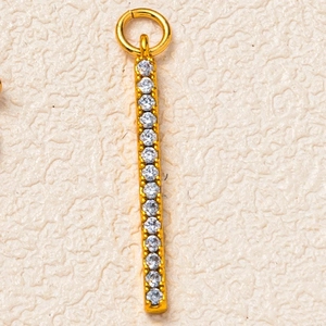 Macro shot of gold-plated long bar pendant featuring sixteen cubic zirconia in claw settings