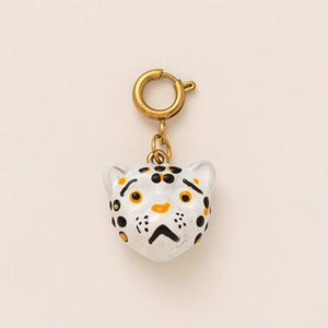 Macro view of leopard print enamel animal pendant with polished golden metal ring clasp