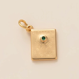 Detailed view of 18K gold passport pendant with eagle crest and green zircon stone