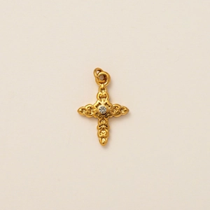 Macro view of vintage gold stainless steel cross pendant with embossed floral patterns