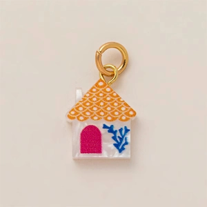 Detail view of colorful house pendant with 18K gold ring and vibrant painted roof details