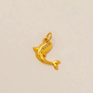 Close-up of gold dolphin pendant with white zircon stones on warm beige background