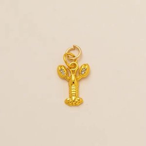 Detailed macro view of 18K gold lobster pendant with white zircon inlaid details