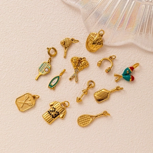 Golden sports pendants collection with tennis racket, surfboard and fitness charms on fabric