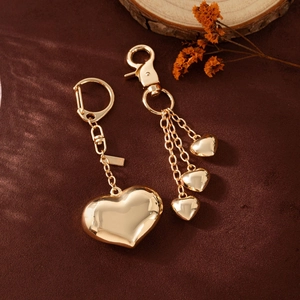 Polished gold heart charms for bags featuring smooth mirror finish and versatile ring clips