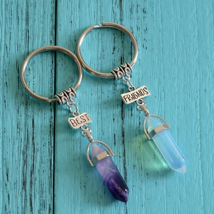 Set of two Best Friends hexagonal crystal pillar keychains on vintage wood background