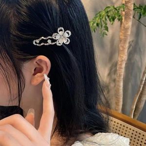 Pince à cheveux fleur argentée ondulée avec pierres œil de chat et strass