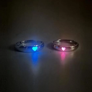 Dettaglio di anelli a cuore luminosi in blu e rosa con fascia regolabile