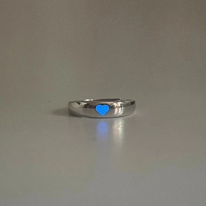 Dettaglio dell'anello a cuore argento con effetto luminoso blu fluorescente