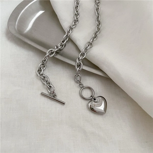 Dettaglio del ciondolo a cuore con chiusura OT su una collana a catena spessa