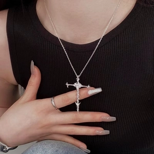 Detail of vintage silver cross pendant with gothic bone texture on a male model