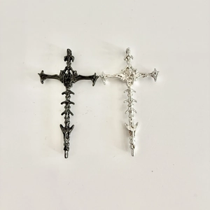 Detailed macro view of dark gothic cross pendants in black and silver metallic finish