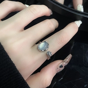 Detail view of flower bud moonstone open ring featuring a polished silver finish