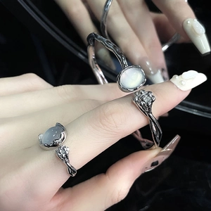 Detail of twisted silver cuff bracelet and ring set with moonstone and floral diamond accent