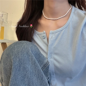 Close-up van de minimalistische witte kralen choker ketting gedragen voor een zomerse look