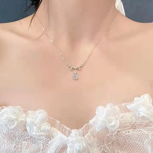 Macro detail of silver water drop necklace with moonstone pendant on skin