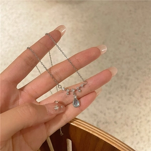 Detailed close-up of a silver teardrop moonstone pendant necklace held in hand