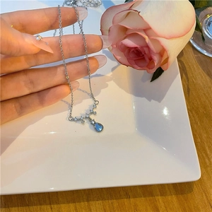 Detailed shot of teardrop moonstone pendant necklace with blue stone on silver chain