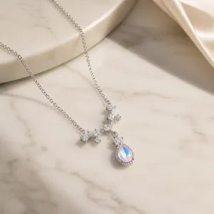 Close-up of silver teardrop moonstone pendant with sparkling V-shaped zircon stones