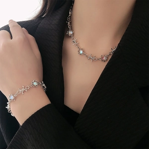 Détail du collier barbelé argenté et bracelet assorti avec pierre de lune irisante