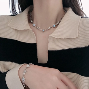 Gros plan d'un collier en fil barbelé avec pierre de lune sur chemise rayée