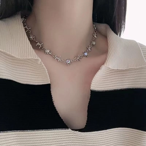Gros plan du collier en chaîne à épines argentées avec pierre de lune irisées