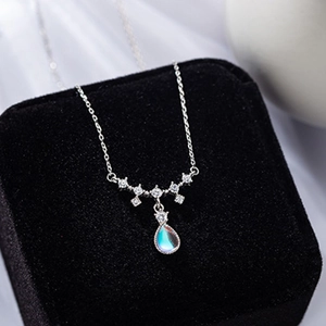 Close-up of teardrop moonstone pendant with blue shimmer and sparkling diamonds