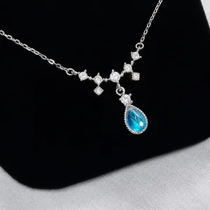 Detailed close-up of water drop blue gemstone pendant with white zircon on silver chain