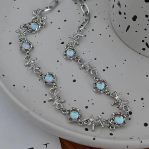 Vue détaillée du collier épines argenté avec pierre de lune bleue sur un plateau blanc
