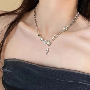 Detailed view of moonlight cross necklace with opal stone on model neck