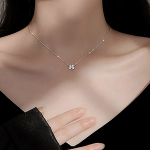 Silver four-leaf clover pendant necklace with cubic zirconia worn by a model