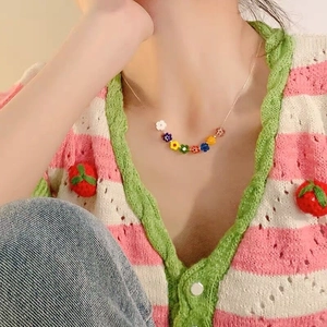 Detailopname van een kleurrijke glazen bloemenketting met kralen op een zilveren ketting
