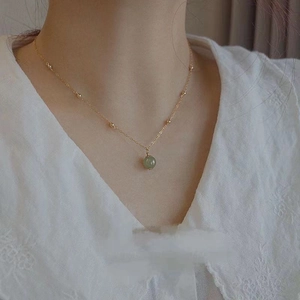 Elegant 18K gold chain necklace featuring a polished green Hetian jade bead pendant