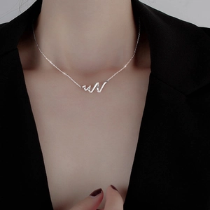 Silver zodiac snake-shaped wave necklace on a model wearing a professional black suit