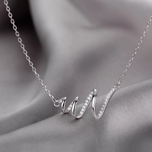 Detailed macro view of silver snake spiral wave necklace pendant with cubic zirconia