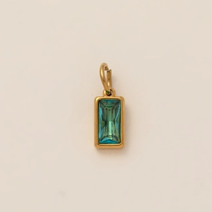 Detail van een minimalistische gouden hanger met een rechthoekige groenblauwe edelsteen