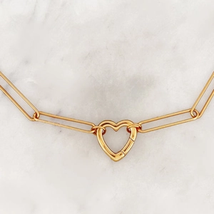 Detail of 18K gold-plated necklace with heart-shaped carabiner and paperclip chain