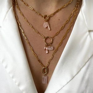 Detailed layered 18K gold-plated necklaces with pink pendants on a model's neck