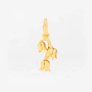 Macro detail of gold lily of the valley flower pendant with polished metallic finish