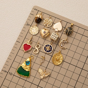 Variété de pendentifs dorés 18K avec lune et pierres naturelles sur un tapis quadrillé