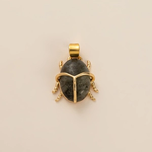 Detailed view of a golden beetle pendant featuring a natural grey oval gemstone inlay