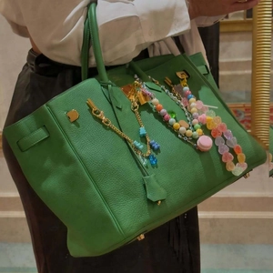 Green leather handbag with colorful beads and macaron charms in a classic design style