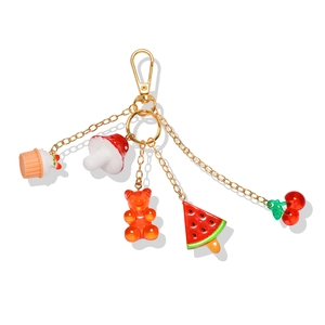 Close-up of colorful beads and resin charms like cupcake and cherries on a gold keychain